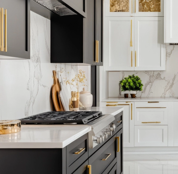 A bright, newly renovated kitchen with dark cabinets and gold hardware.