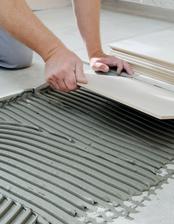 A professional remodeler laying new tile in a home.