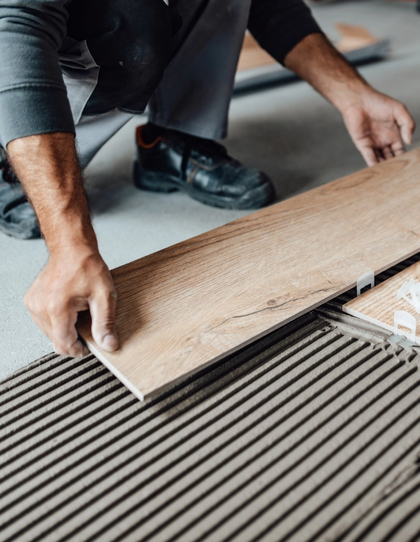 A professional remodeler installs flooring as part of a home remodel.