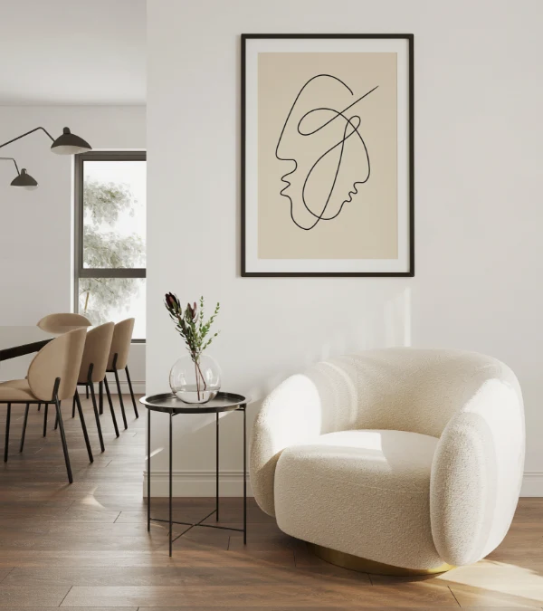 A modern living space in a new construction featuring a white rounded armchair, a small side table with a vase, abstract line art on the wall, and a dining area in the background.